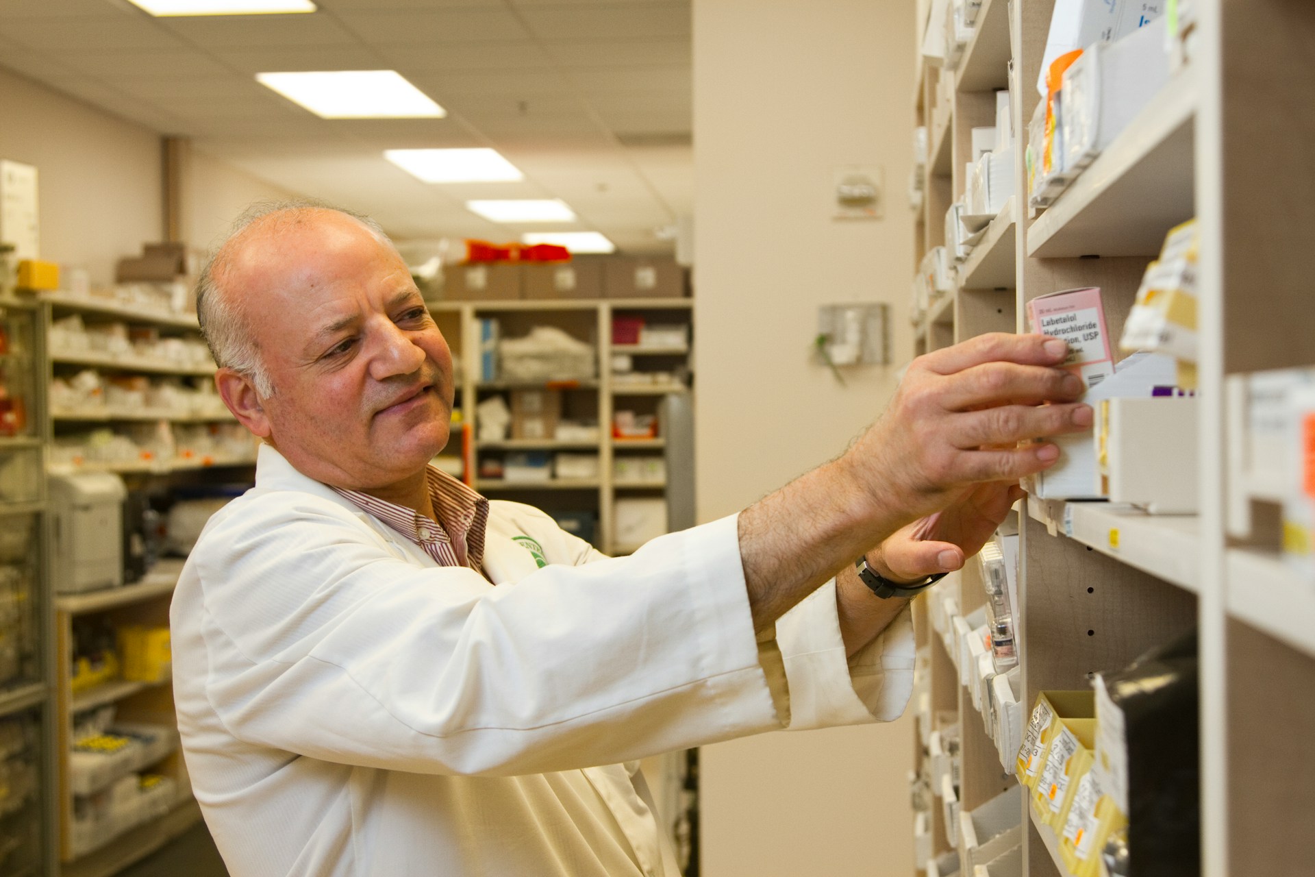A pharmacist checking medication against a filled prescription
