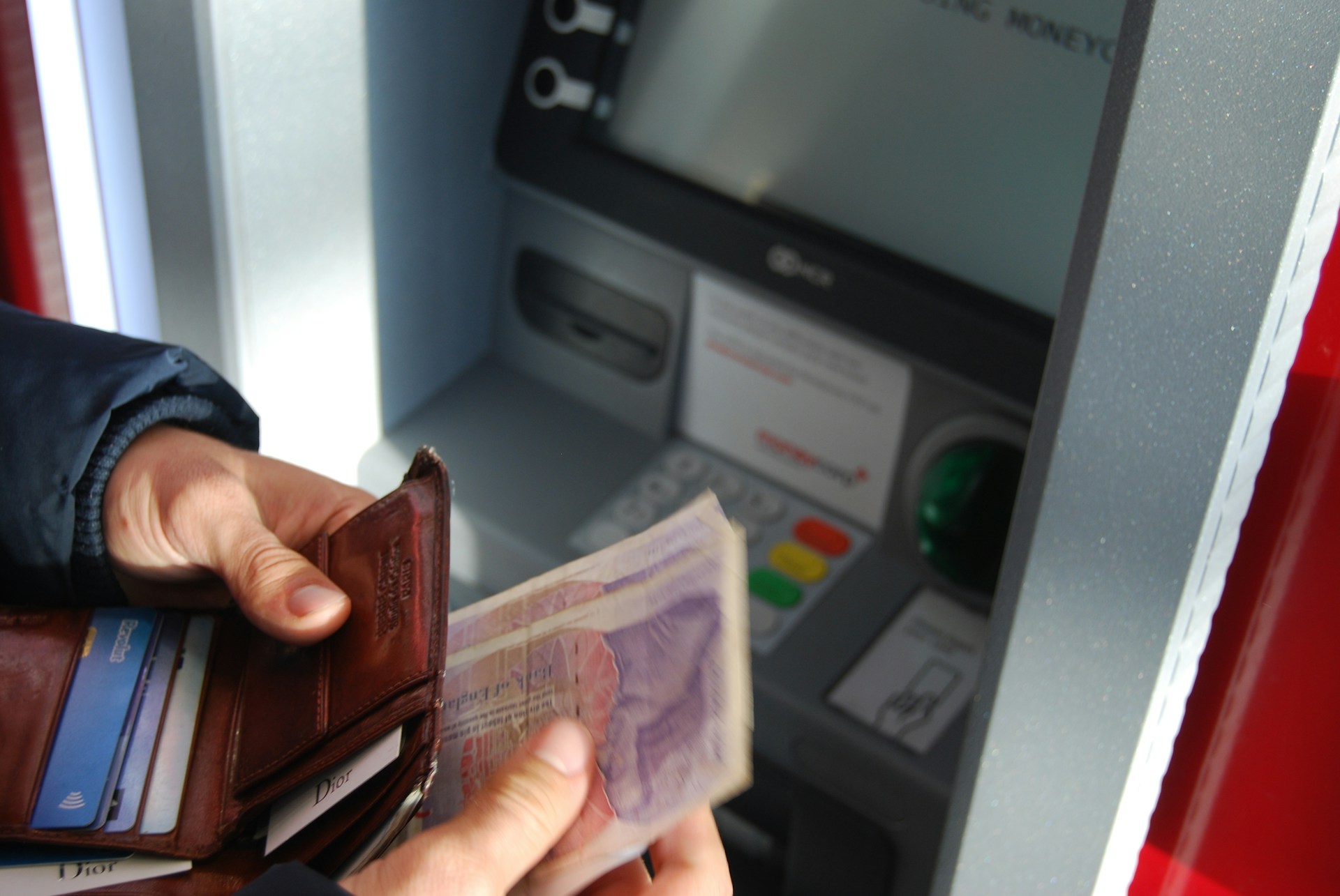 A person counting cash withdrawn from an ATM